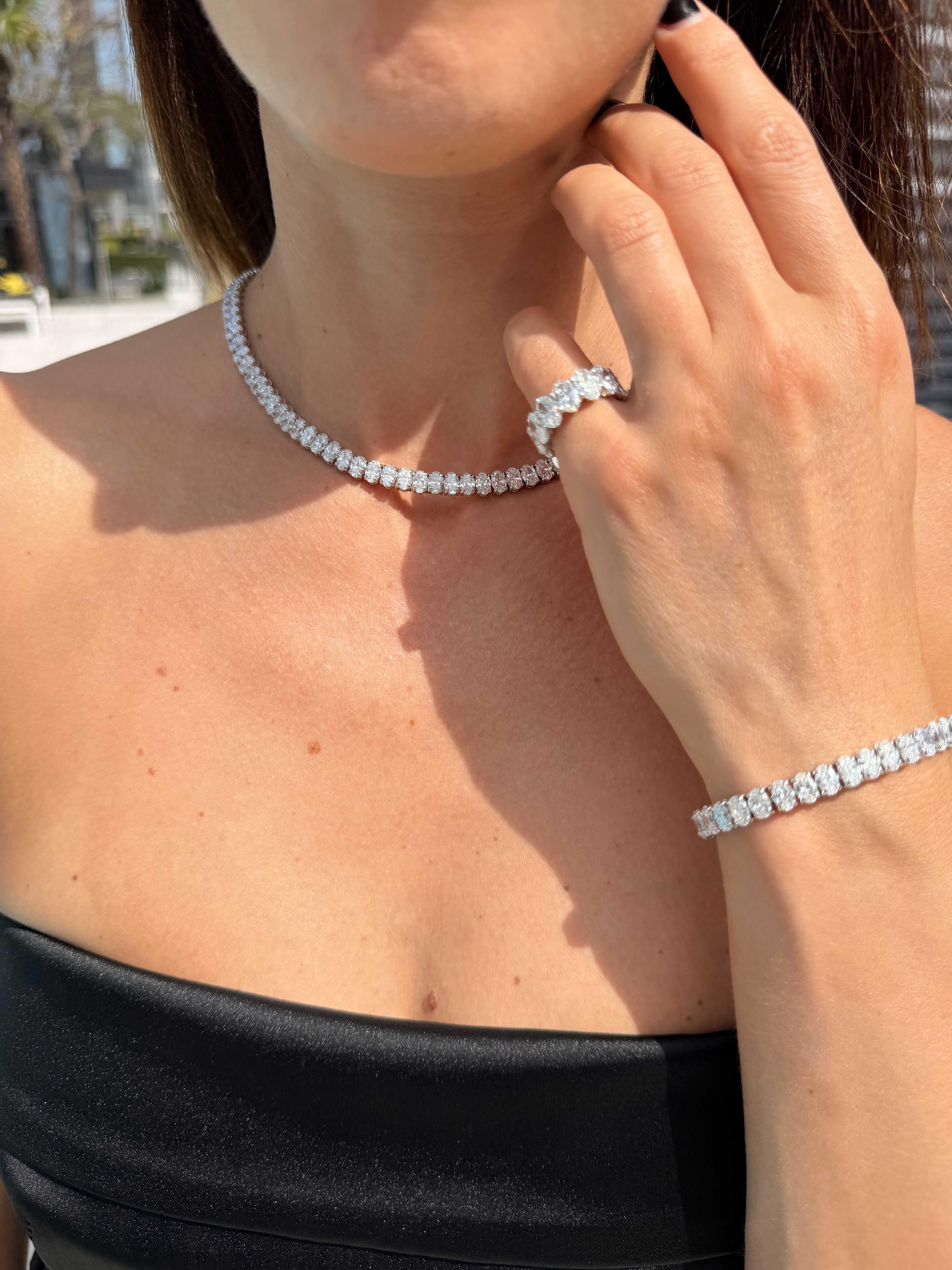 Diamond tennis necklace and ring worn in sunlight