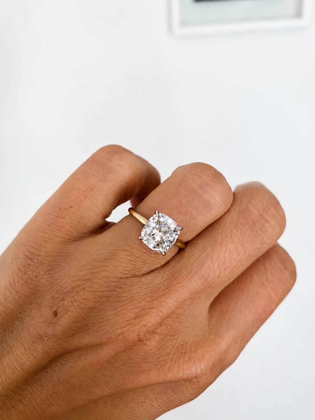 Round diamond engagement ring worn on a hand