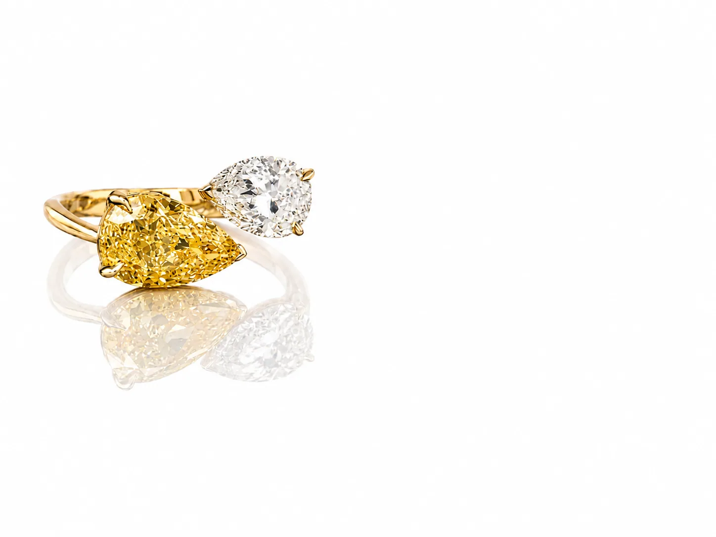 Emerald and pear-shaped gemstone rings in yellow gold