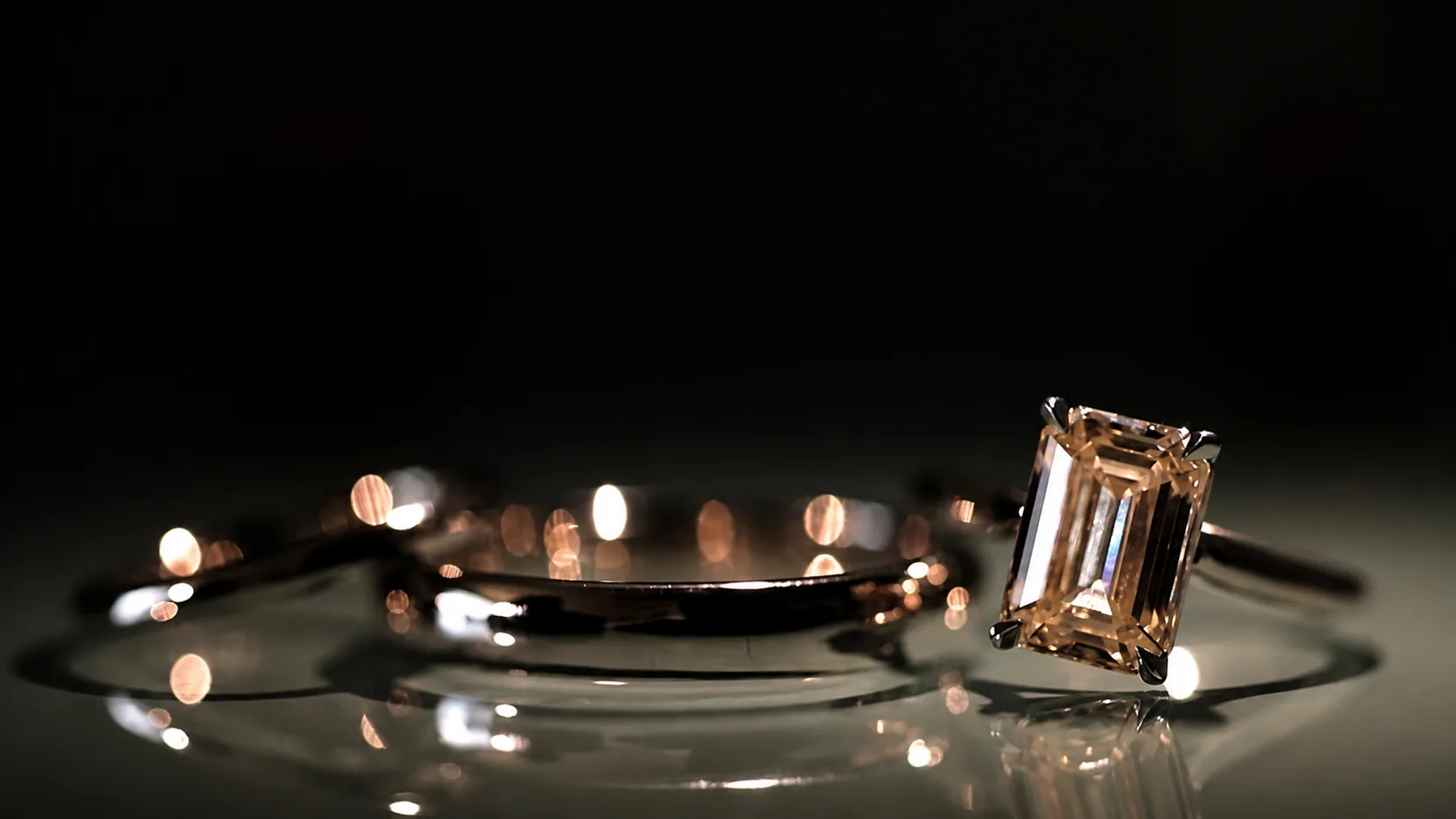 Custom rings photographed on a dark reflective surface